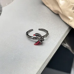 Detaillierte Makroaufnahme eines gotischen schwarzen Metallrings mit rotem Mondakzent