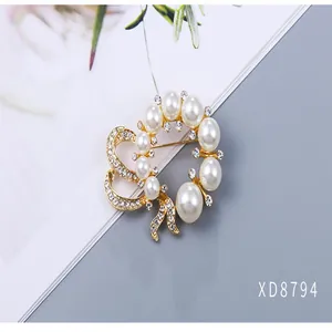 Detailed view of elegant pearl and crystal floral brooch with a gold-toned metal base