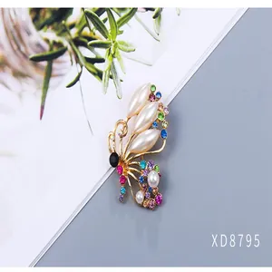 Detailed view of a butterfly brooch with elegant pearls and colorful rhinestones.