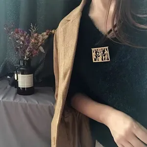 Vintage gold Egyptian relief brooch pinned on a black sweater for a retro style look.