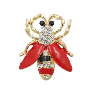 Exquisite gold-tone bee brooch with vibrant red enamel wings and sparkling rhinestones