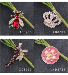 Detailweergave van vier vintage broches met insecten-, kroon- en strikmotieven.