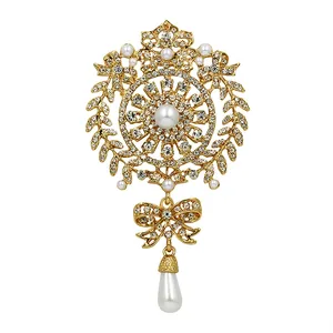 Detailed view of a vintage gold crystal brooch with pearls and a bow-shaped drop
