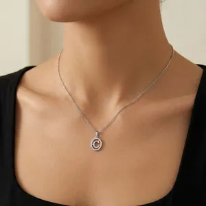 Primo piano di un'elegante collana con ciondolo lettera C in zirconi su modella