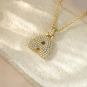 Close-up of gold iced-out initial A pendant necklace with micro-pave stones.