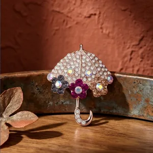 Elegante spilla a ombrello con fiori, strass scintillanti e accenti floreali per maglia