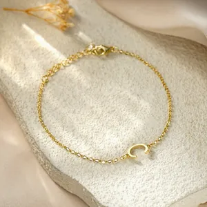 Detailed macro view of a stylish gold titanium steel bracelet with a letter C charm