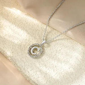 Primo piano di un'elegante collana in argento con ciondolo a lettera C e zirconi pavé