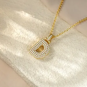 Exquisite macro detail of a gold pavé letter D pendant necklace featuring sparkling stones