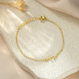 Detailed view of gold-plated stainless steel chain bracelet with letter F pendant