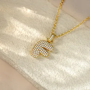 Detailed view of a gold hip-hop pendant necklace with pave-set stones in the shape of letter F