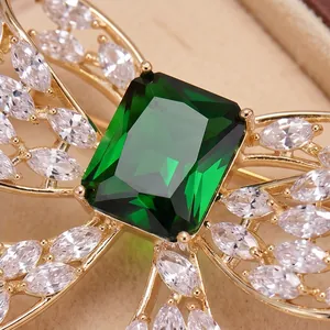 Elegant butterfly bow brooch with an emerald green stone and white zircon accents