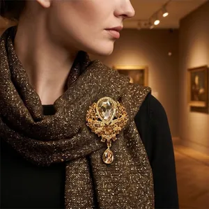 Elegant vintage water-drop crystal brooch pinned on a luxury shimmering brown scarf