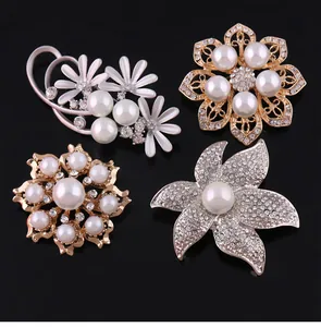 Detailed view of four elegant floral brooch pins with pearls and rhinestones on black background