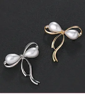 Nahaufnahme eleganter Schleifenbrosche in Gold und Silber mit Perlen