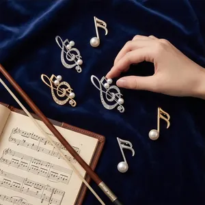 Elegant musical note pearl brooches in gold and silver finish set on blue velvet.