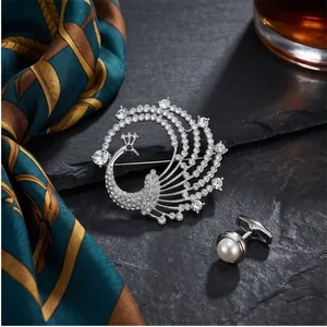Elegant silver peacock brooch with sparkling crystals and a round white pearl pin.