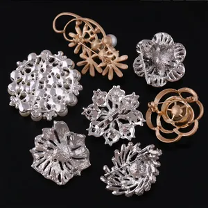 Detail view of various elegant metal brooches showing the back pin mechanism.