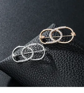 Detailansicht ineinandergreifender Kreisbrosche mit Strass in Gold- und Silberoptik