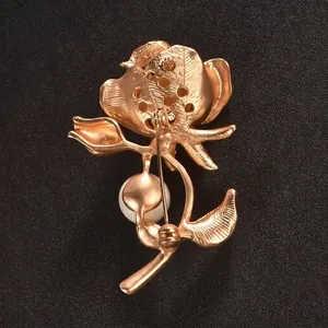Elegant gold floral brooch with white pearl accent shown from back view with safety pin