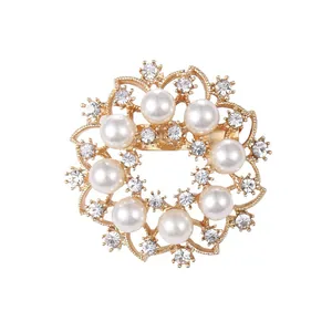 Elegant circular gold brooch with white pearls and sparkling rhinestones for suits.