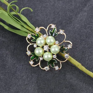Elegante goudkleurige bloemspeld met groene parels en fonkelende strass damesjassen