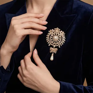 Elegant vintage crystal flower brooch with hanging teardrop pearl on navy velvet blazer