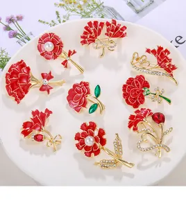 Detailed view of various red enamel carnation and rose brooches with pearl accents