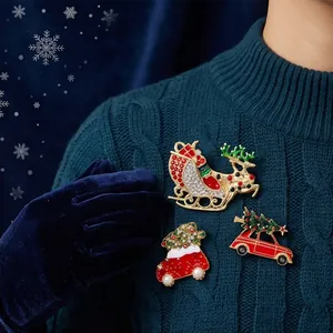 Close-up of Christmas brooches with reindeer sleigh and tree on a blue sweater