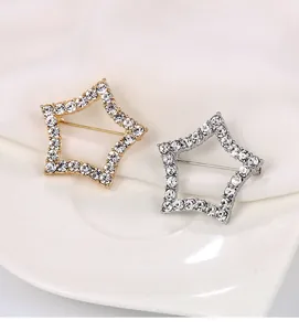 Elegante goldene und silberne Stern-Broschen mit funkelnden Kristallen in Nahaufnahme.