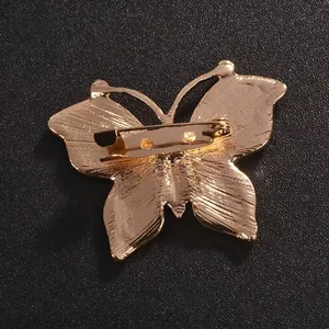 Back view of a gold-plated butterfly brooch with a secure pin clasp for clothing.