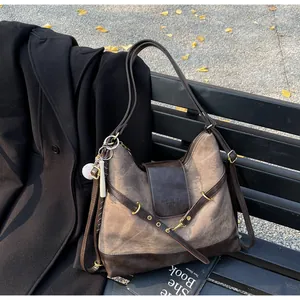Bolso bandolera retro marrón de gran capacidad en un banco de parque para el trabajo