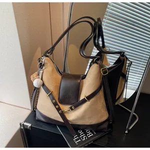 Bolso hobo vintage de gran capacidad en contraste con amuleto de béisbol y cuero