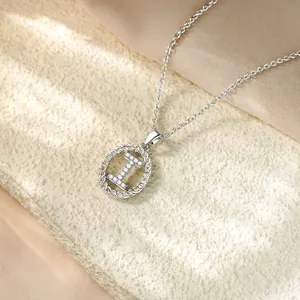 Primo piano di una collana argentata con un ciondolo a lettera I in zirconi micro-pave.