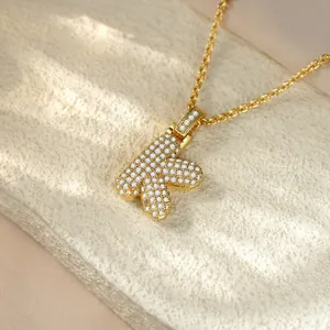 Detailed macro view of golden hip hop iced out initial K pendant necklace for women