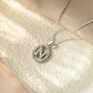 Primo piano di un'elegante collana in argento con ciondolo a forma di lettera N e zirconi