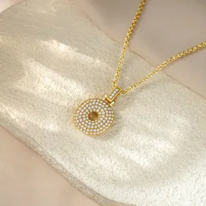 Close-up of golden hip-hop necklace with full diamond iced-out circular pendant