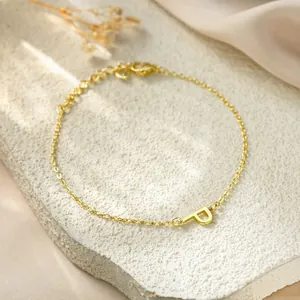 Detailed view of gold titanium steel bracelet featuring a minimalist letter P pendant