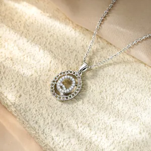 Dettaglio della collana con ciondolo lettera Q in zirconi su una pietra elegante