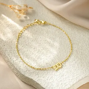 Detailed macro view of a gold titanium steel bracelet with an 'R' pendant