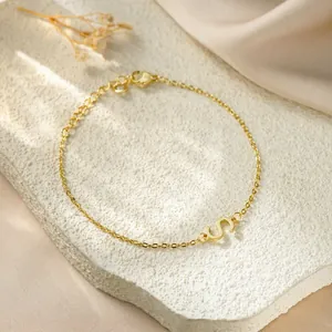 Detailed close-up of a gold-plated titanium steel bracelet featuring a letter S charm
