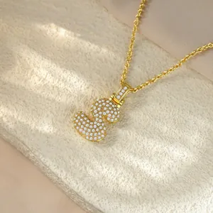 Close-up of a gold hip-hop necklace with a sparkling iced-out S letter pendant