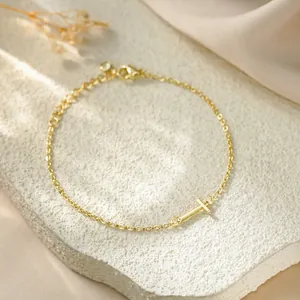 Detailed close-up of a gold titanium steel chain bracelet with a polished letter T charm.