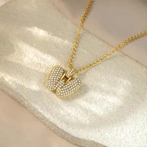 Detail shot of a gold-toned iced out letter pendant necklace set with glittering crystals