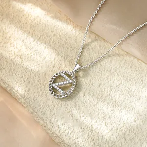 Dettaglio macro di una collana argentata con un pendente a lettera Z in zirconi lucidi.