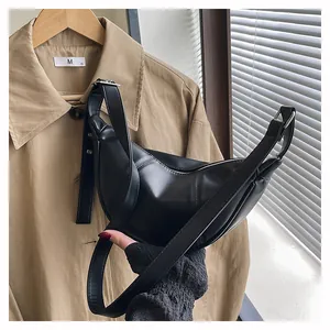 Detail einer minimalistischen schwarzen Halbmond-Tasche aus PU-Leder mit Riemen