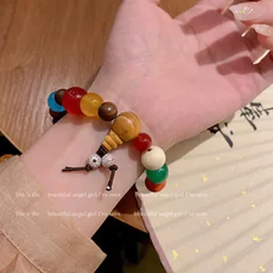 Vista detallada de una pulsera de cuentas de cerámica en colores macarrón en una muñeca