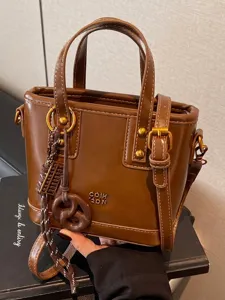 Vintage brown women's bucket bag with unique abacus charm in high-quality PU leather