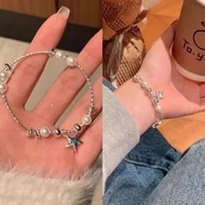 Detailed view of an elegant silver pearl bracelet featuring a star charm pendant.
