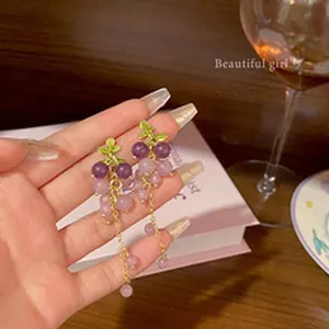 Detailed view of grape-shaped earrings featuring purple beads and gold-tone chain drop